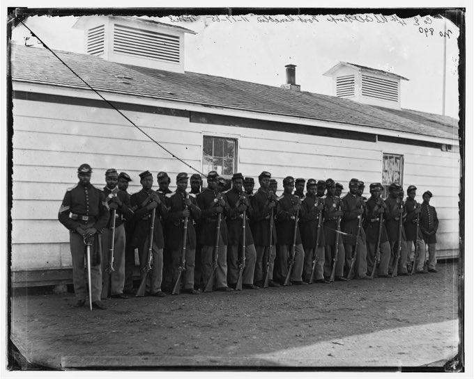 Company E of the 4th U.S. Colored Infantry standing in ranks at Fort Lincoln, between 1863 and 1866, with machine-detected face and insignia regions outlined.
